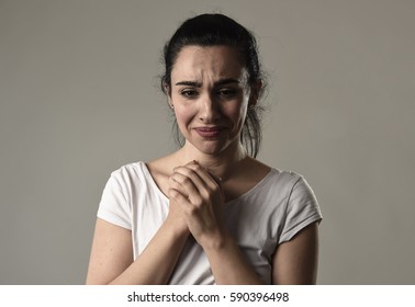 beautiful face of sad woman crying desperate and depressed with tears on her eyes suffering pain and depression isolated on grey background in sadness facial expression and emotion concept