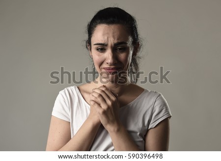 beautiful face of sad woman crying desperate and depressed with tears on her eyes suffering pain and depression isolated on grey background in sadness facial expression and emotion concept