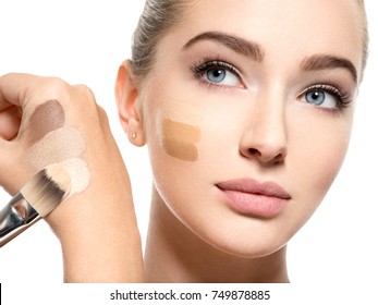 Beautiful face of  young woman with cosmetic foundation on a skin.   Beauty treatment concept