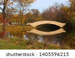 Beautiful fall landscape with a bridge in the city park. Colored trees and bridge in sunlight reflected in the water. Tenney Park, Madison, Midwest USA, Wisconsin.