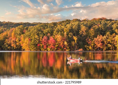 beautiful fall reflections in a lake with a fishing boat during sunset