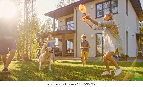 Beautiful Family Of Four Play Catch Toy Ball With Happy Golden Retriever Dog On The Backyard Lawn. Idyllic Family Has Fun With Loyal Pedigree Dog Outdoors In Summer House Backyard.