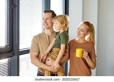 Beautiful Family With Kid Boy Have Rest In New House, Drinking Coffee, Smiling. Happy Future Is Coming. Dreams Come True. Home Renovation, New Apartment, Family Concept