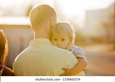 Beautiful Family, Mother, Father And Three Kids, Boys, Having Familly Outdoors Portrait Taken On A Sunny Spring Evening, Beautiful Blooming Garden, Sunset Time, Back Lit. Parents And Children Have Fun