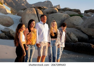 A Beautiful Family On A Beach. Golden Light With Rocks. A Loving Family With Teenager Children. 