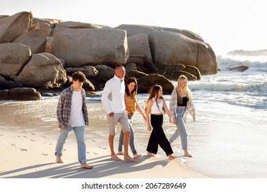 A Beautiful Family On A Beach. Golden Light With Rocks. A Loving Family With Teenager Children. 