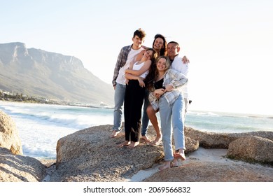 A Beautiful Family On A Beach. Golden Light With Rocks. A Loving Family With Teenager Children. 