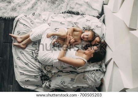 Similar – Relaxed mother and sons playing over the bed