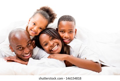 Beautiful family portrait lying in bed and smiling - isolated over white 
