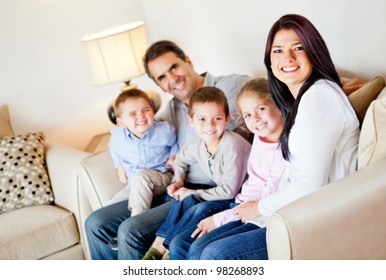 Beautiful Family Portrait Sitting In The Living Room At Home