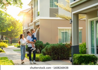Beautiful Family Portrait Smiling Outside Their New House With Sunset, This Photo Canuse For Family, Fathe, Mother And Home Concept