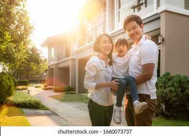 Beautiful Family Portrait Smiling Outside Their New House With Sunset, This Photo Canuse For Family, Father, Mother And Home Concept