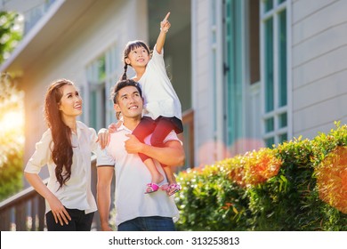 Beautiful family portrait smiling outside their new house with sunset 