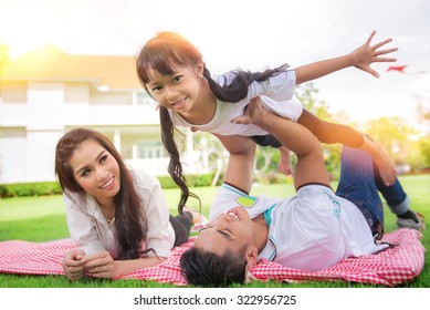 Beautiful Family Portrait Smiling Outside Their New House, Picknic And Outdoor Concept
