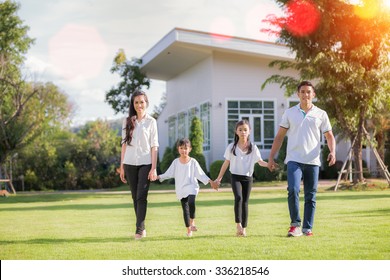 Beautiful Family Portrait Smiling Outside Their New House With Sun Light