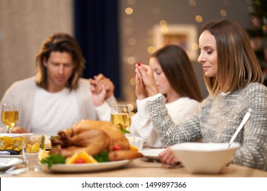 Beautiful Family Praying Over Festive Dinner At Home