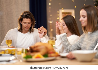 Beautiful Family Praying Over Festive Dinner At Home