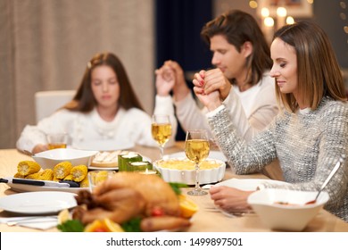 Beautiful Family Praying Over Festive Dinner At Home