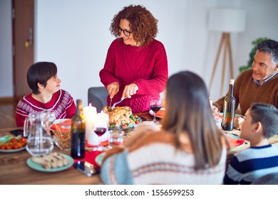 Beautiful family smiling happy and confident. One of them curving roasted turkey celebrating christmas at home - Shutterstock ID 1556599253