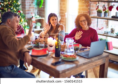 Beautiful family smiling happy and confident. Eating roasted turkey make videocall using laptop celebrating christmas at home - Powered by Shutterstock