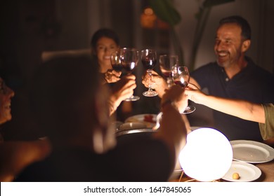 Beautiful family toasting with cup of wine on dinner smiling at terrace - Powered by Shutterstock