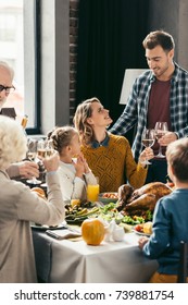 beautiful family toasting with white wine glasses on holiday dinner