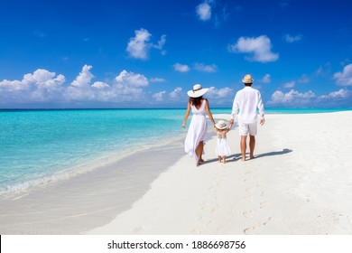 A Beautiful Family Walks Together On A Tropical Paradise Beach In The Maldives With Turquoise Ocean And White Sand During Their Vacation Time