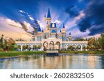 Beautiful fantastic fairy tale castle by lake at Magic City amusement Park in Tashkent in Uzbekistan at sunset