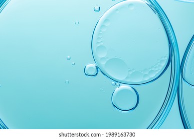 Beautiful and fantastic macro photo of water droplets in oil with a blue background. Abstract art 