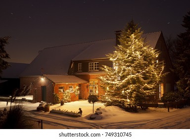 A Beautiful Farm House With A Tall Christmas Tree And A Lot Of Fresh Snow At Night.