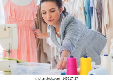 Beautiful fashion designer fixing dress on a mannequin - Powered by Shutterstock