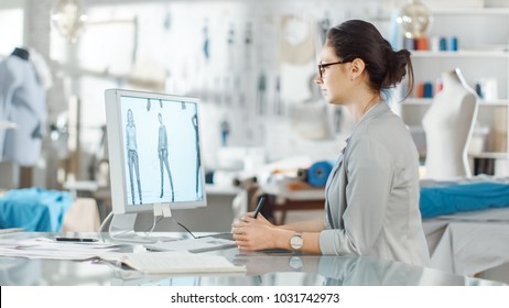 Beautiful fashion, designer,  Sits at Her Desk before Personal Computer, Using Digital Drawing Tablet. Her Studio is Sunny, Full of Colorful Details, Fabrics, Sewing Items, Sketches. - Powered by Shutterstock