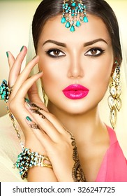 Beautiful fashion Indian woman portrait with oriental accessories- earrings, bracelets and rings. Indian girl with black henna tattoos and beauty jewels. Hindu model with perfect make-up. India