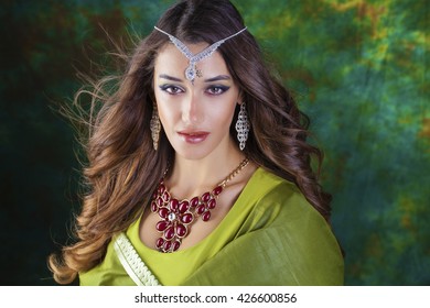 Beautiful fashion Indian woman portrait with oriental accessories earrings. Arabic girl with beauty jewels. Hindu model with perfect make-up. India