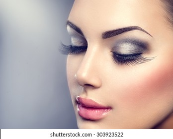 Beautiful Fashion Luxury Makeup, long eyelashes, perfect skin facial make-up. Beauty Brunette model woman holiday make up close up. Eyelash extensions, false eyelashes.  - Powered by Shutterstock