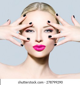 Beautiful fashion model girl with blond hair, darl manicure and bright make up. Portrait of glamour woman with makeup over grey background. Beauty female face close up with perfect make-up