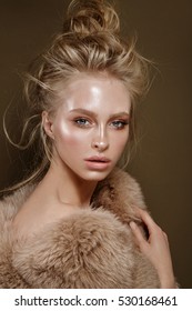 Beautiful Fashion Portrait Of A Girl With Glossy, Glowing And Radiant Skin, A Long Neck, Cusioning Noobies , Disheveled Natural Hair, In Fur, On A Neutral Background, And The Savage