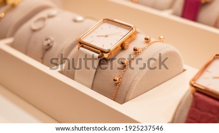Beautiful fashion watch with leather strap and a gold bracelet in the shop window