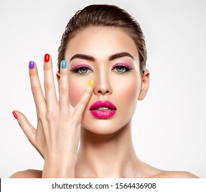 Beautiful fashion woman with a colored nails. Attractive white girl with multicolor manicure. Glamour fashion model with bright gloss make-up posing at studio. Stylish fashionable concept. Art