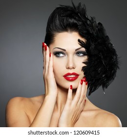 Beautiful fashion woman with red nails, creative hairstyle and makeup - Model posing in studio