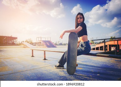 Beautiful and fashion young woman posing with a skateboard
at skate park - Shutterstock ID 1896920812