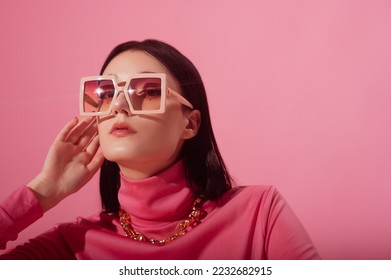Beautiful fashionable confident woman wearing trendy pink butterfly square sunglasses, chunky chain necklace, stylish turtleneck top. Close up studio portrait. Copy, empty space for text - Shutterstock ID 2232682915