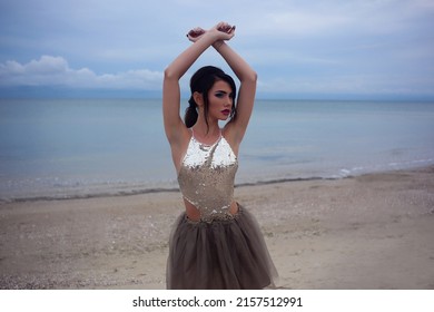 Beautiful Fashionable Girl Stands On The Seashore Of The Sia In A Chiffon Skirt And A Shiny  Shirt At The Watter