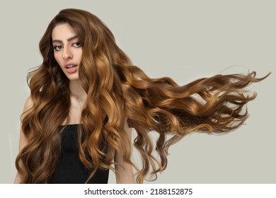 Beautiful Fashionable Woman With Long Curly Big Curls Flying Up. Hairstyle And Makeup