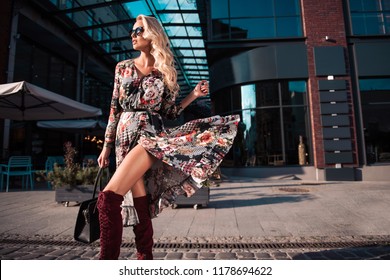 Beautiful Fashionable Woman Walking In The Street, Wearing Sunglasses, Nice Dress, High Heels Boots, Handbag. Fashion Urban Autumn Photo.