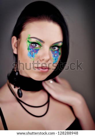 beautiful fashionable young woman with creative art make up in studio