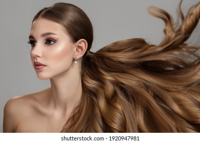 Beautiful Fashionable Young Woman With Long Wavy And Shiny Hair. Brunette With Curly Hairstyle Hair Flying Up