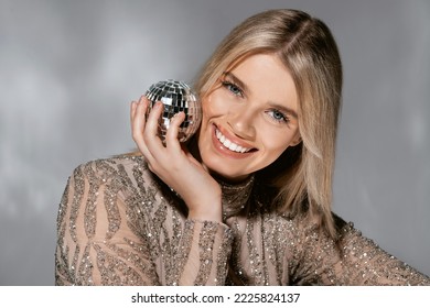 Beautiful Fashionable Young Woman In A Studio Over A Reflective Background, Wearing A Purple Dress, Nice Clothes. Winter Carnival Fashion Photo, Portrait. Blue Gel Light. 