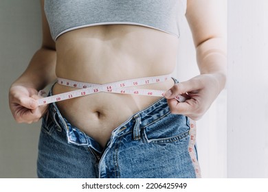Beautiful fat woman with tape measure She uses her hand to squeeze the excess fat that is isolated on a white background. She wants to lose weight, the concept of surgery and break down fat under the - Shutterstock ID 2206425949