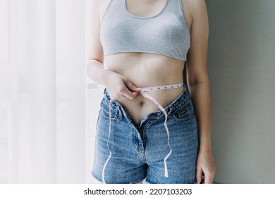 Beautiful fat woman with tape measure She uses her hand to squeeze the excess fat that is isolated on a white background. She wants to lose weight, the concept of surgery and break down fat under the - Shutterstock ID 2207103203